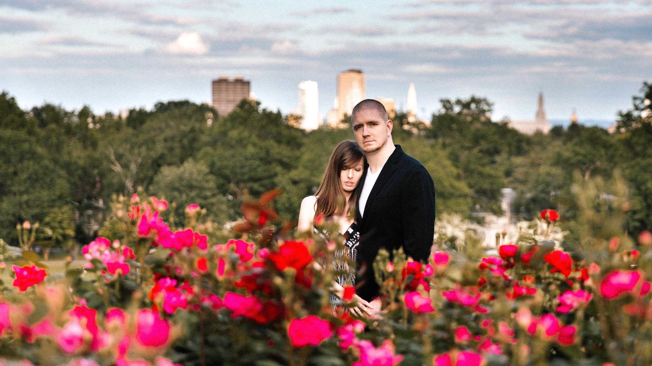 Engaged Couple with flowers in the foreground