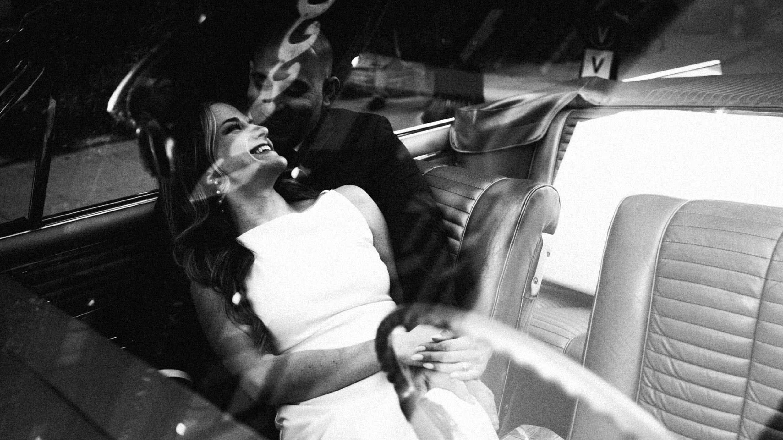 Engaged couple through windshield of an antique car in the North End, Boston