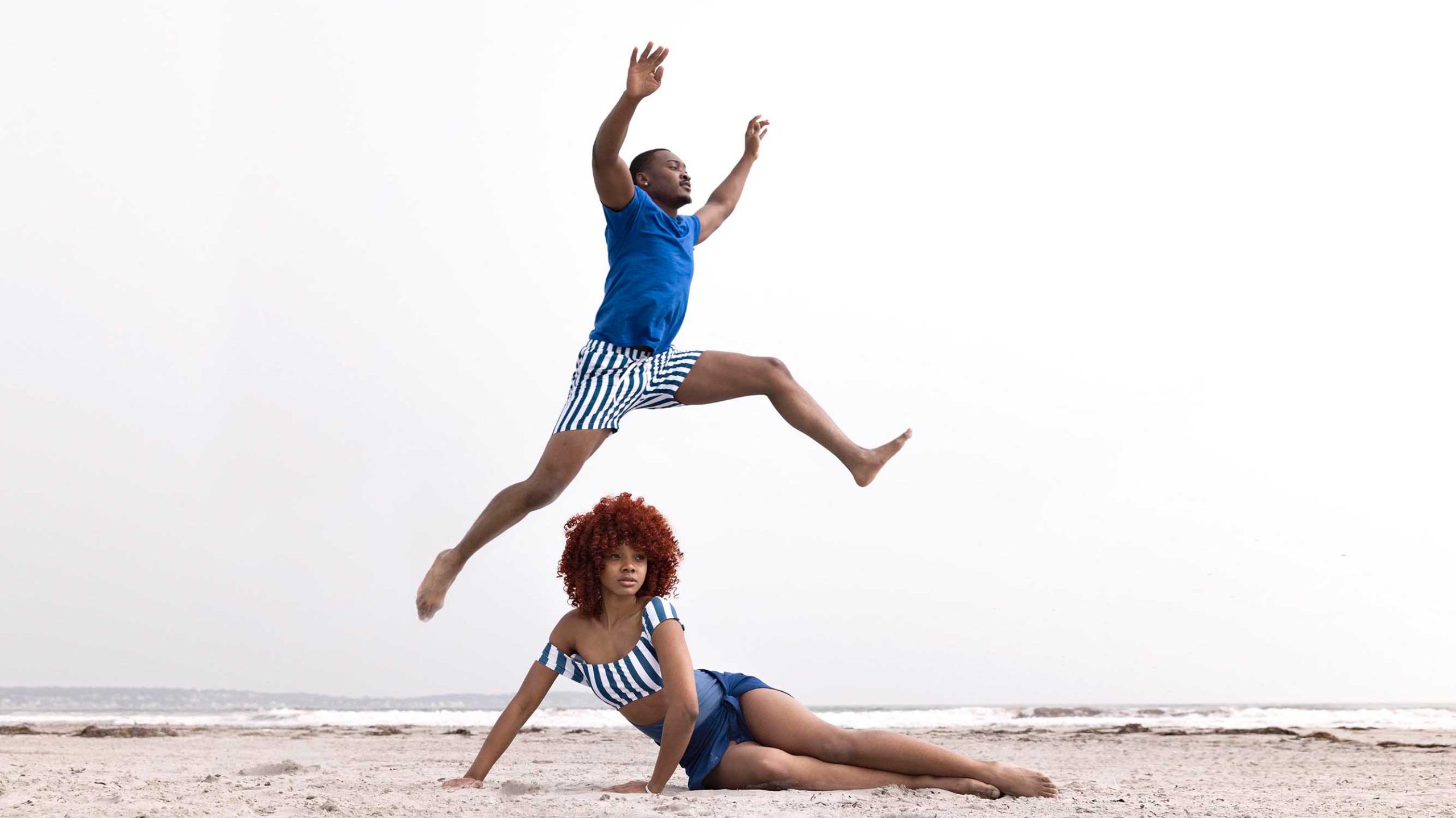 groom is jumping over bride on the beach